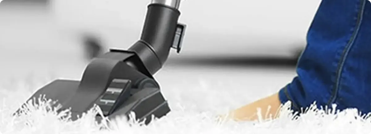 Close-up of a professional vacuuming a white carpet in North Richland Hills.